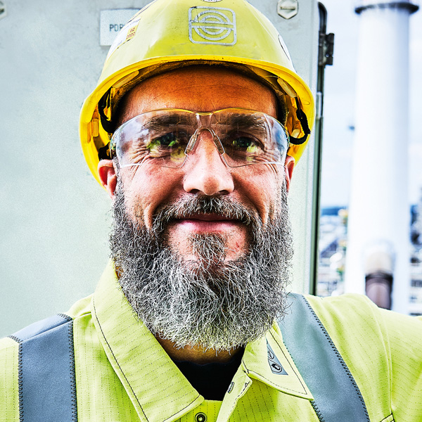 Portrait eines KAEFER Mitarbeiters mit Schutzbrille und Helm
