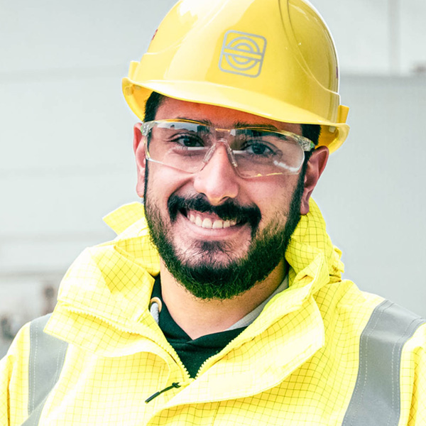 Portrait eines lächelnden Mannes mit Schutzbrille und Helm