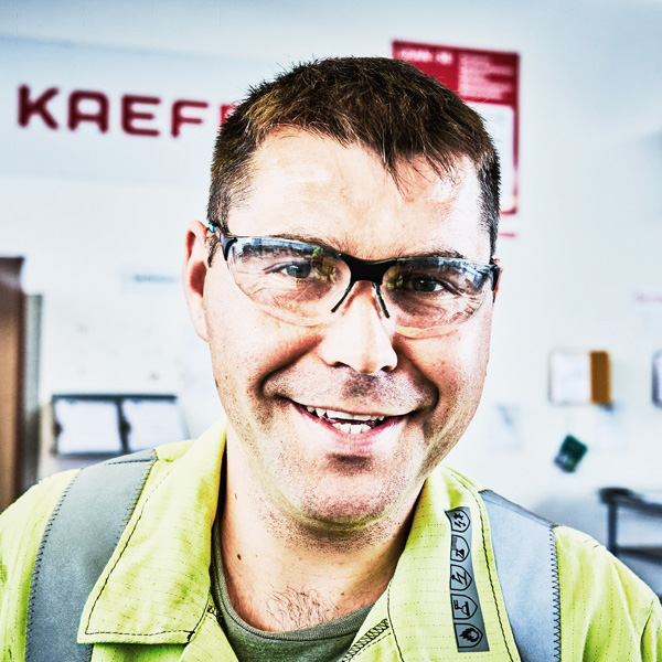 Portrait eines lächelnden Mannes mit Schutzbrille
