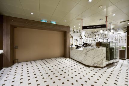 Marbled reception counter in a café area with decorative wall graphics and modern pendant lights
