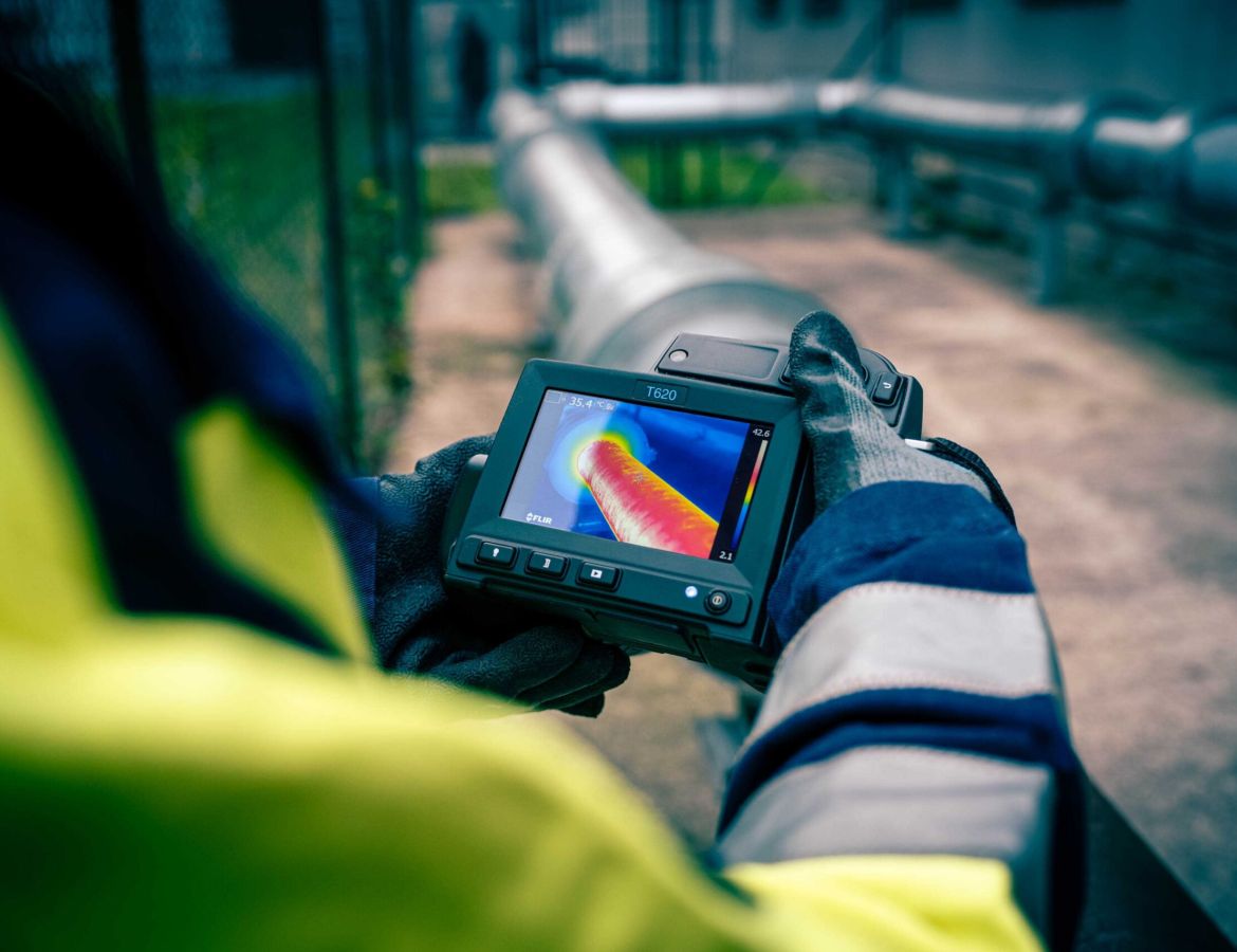 Nahaufnahme auf den Display einer Wärmebildkamera, welche von einem KAEFER Mitarbeiter gehalten wird