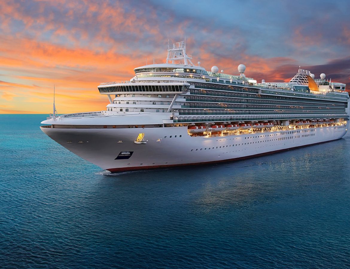 Ein riesiges Kreuzfahrtschiff auf See vor einem Sonnenuntergang