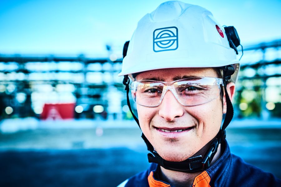 Lächelnder Mann mit Schutzbrille und Helm