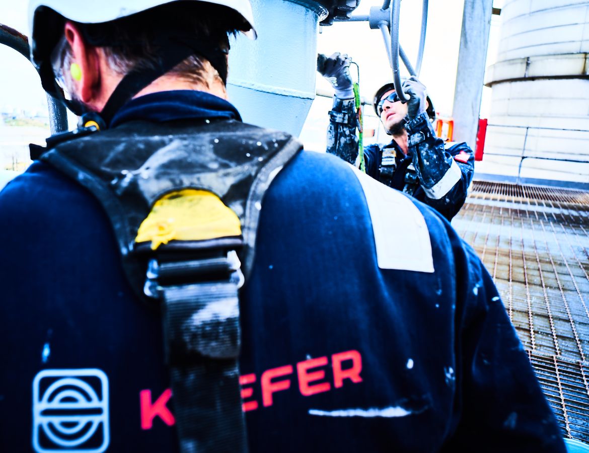 Rückansicht eines Industriekletterers mit KAEFER-Logo auf dem Rücken
