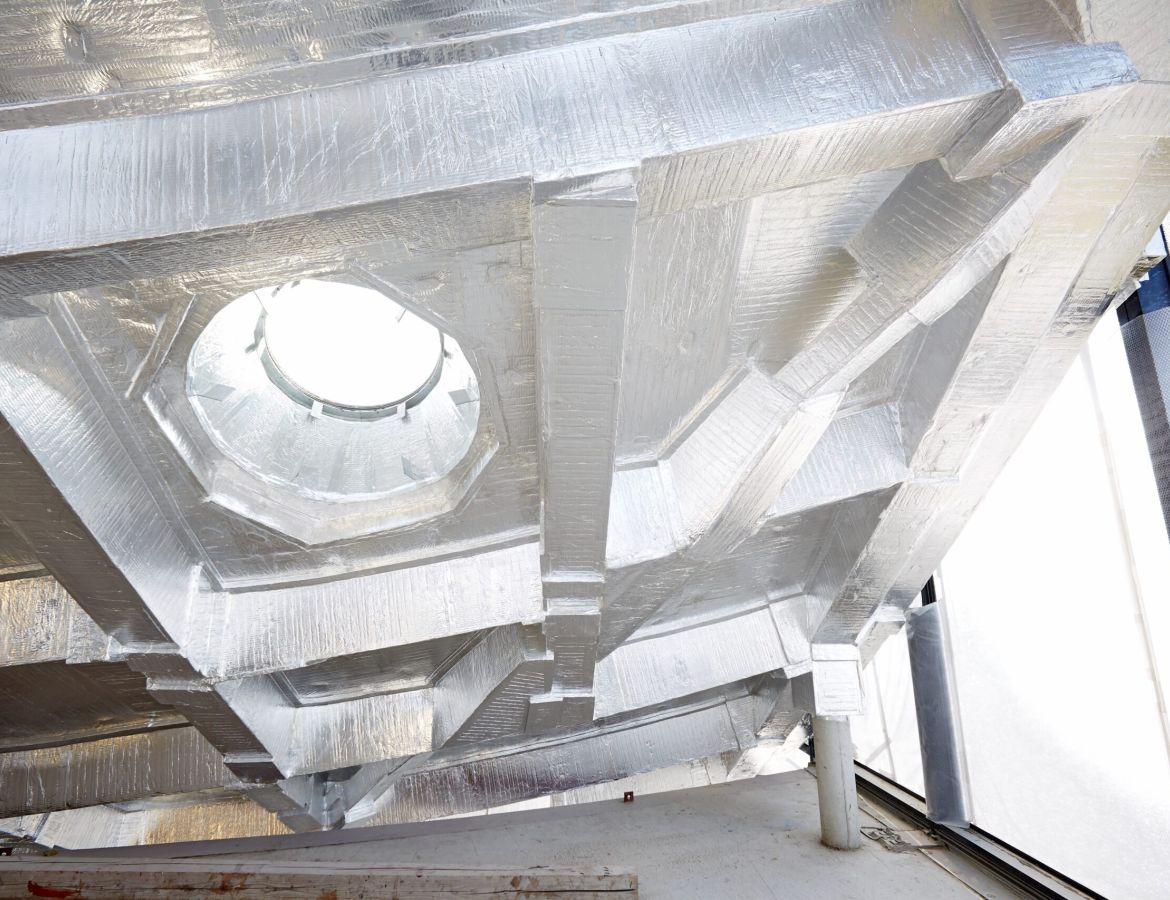 Eine gewölbte Decke, die mit silbernen Brandschutzmatten bedeckt ist