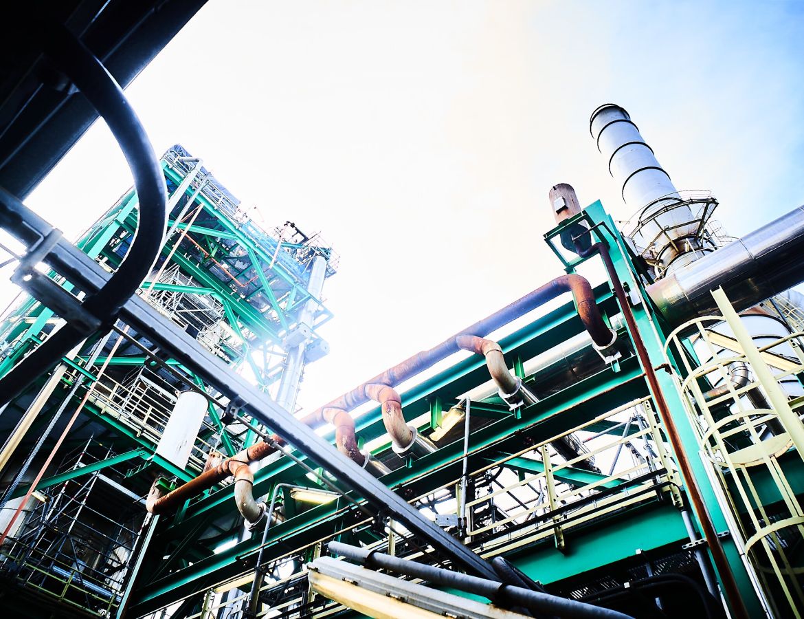 Außenansicht einer Industrieanlage mit Stahltürmen bei Sonnenschein