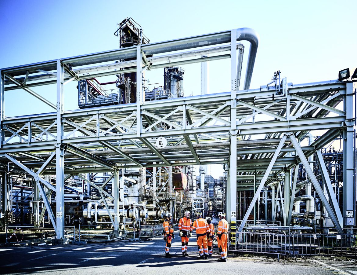 Komplexes System aus blauen Stahlträgern, silbernen Rohrleitungen und Treppenaufgängen